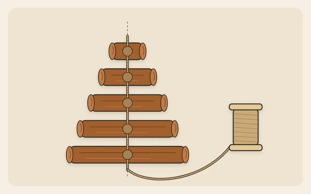 Five cinnamon sticks in decreasing lengths laid out as tree tiers with twine running up the middle