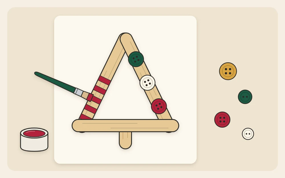 A craft stick triangle tree with painted stripes on one stick and three small buttons along another