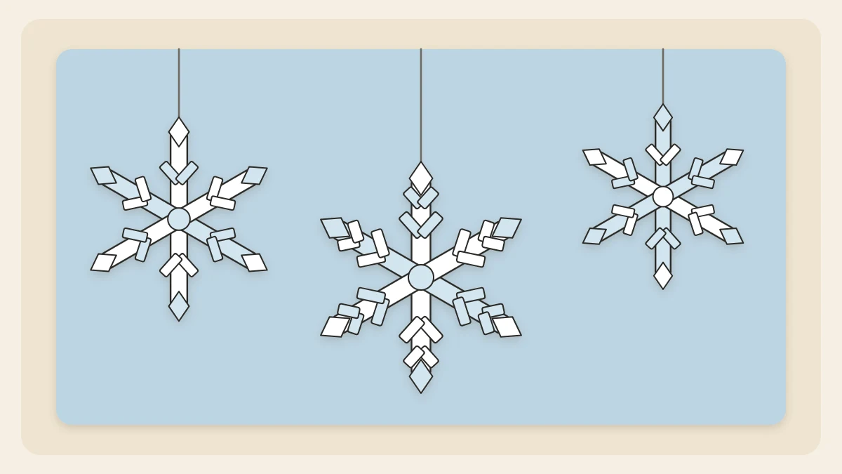 Three white and pale blue six-armed paper snowflake ornaments hanging at different heights on thread loops
