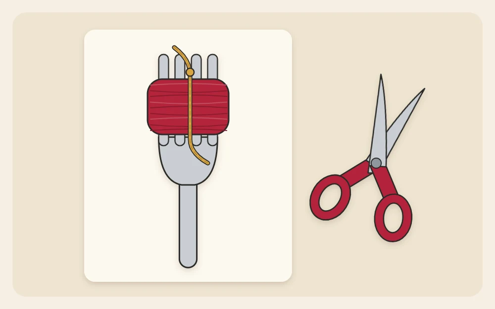 Yarn wound around the tines of a fork with a short strand tied through the middle and scissors beside it